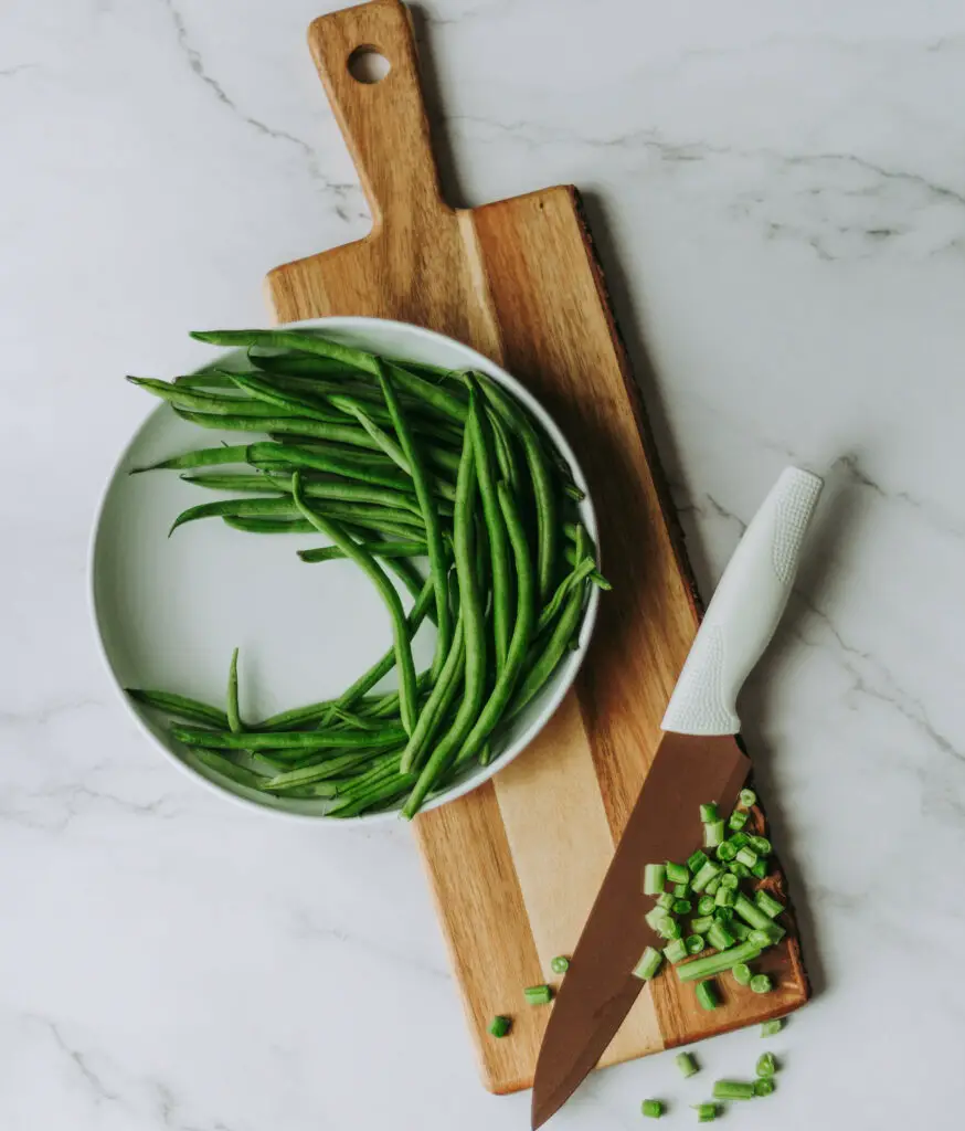 chopped green beans in a board with knife